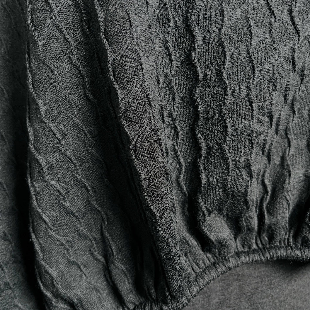 Black textured knit top with bat wing sleeves and gathered hemline black rubber necklace made in Melbourne