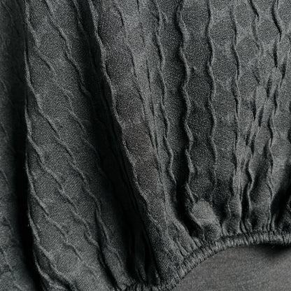 Black textured knit top with bat wing sleeves and gathered hemline black rubber necklace made in Melbourne 