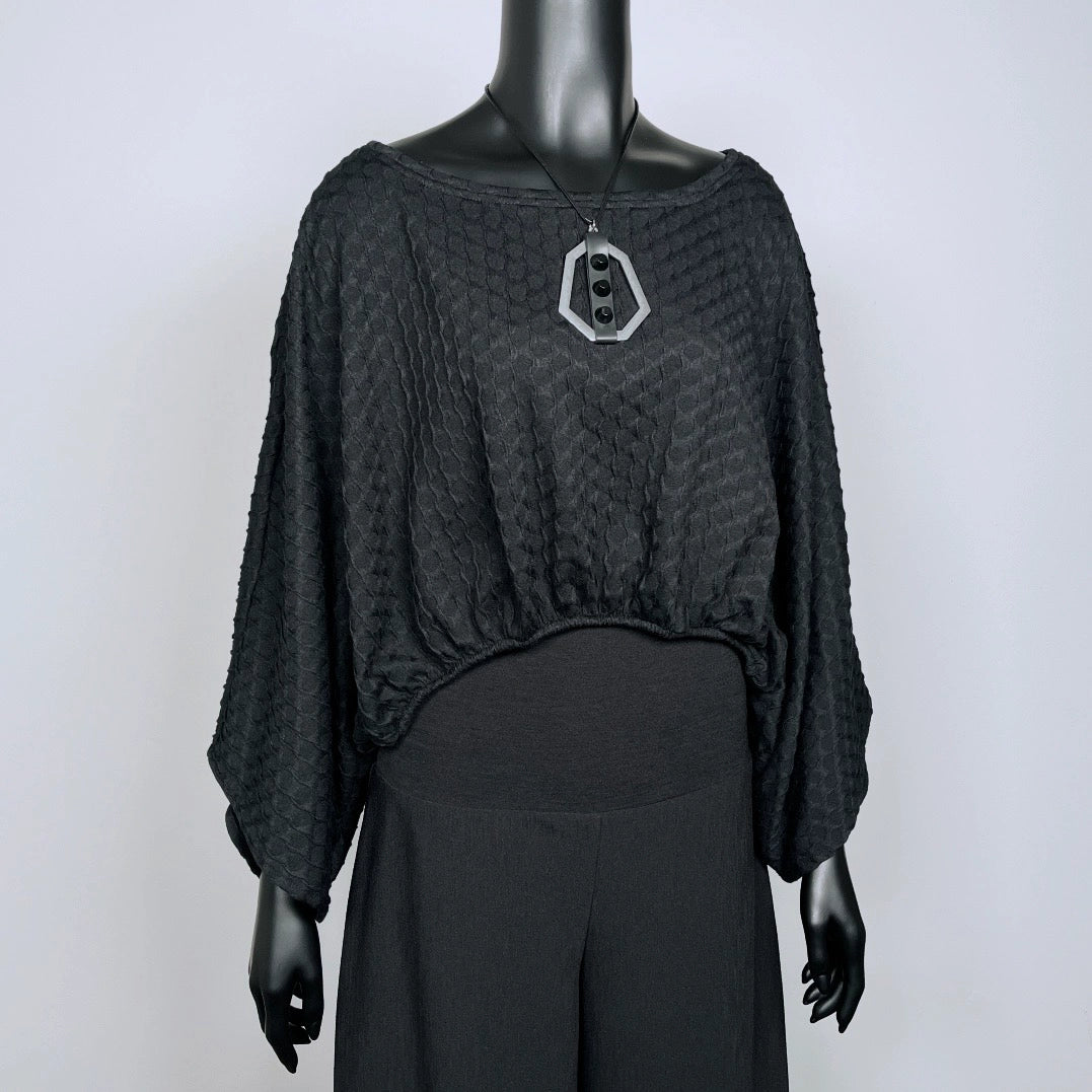 Black textured knit top with bat wing sleeves and gathered hemline black rubber necklace made in Melbourne 