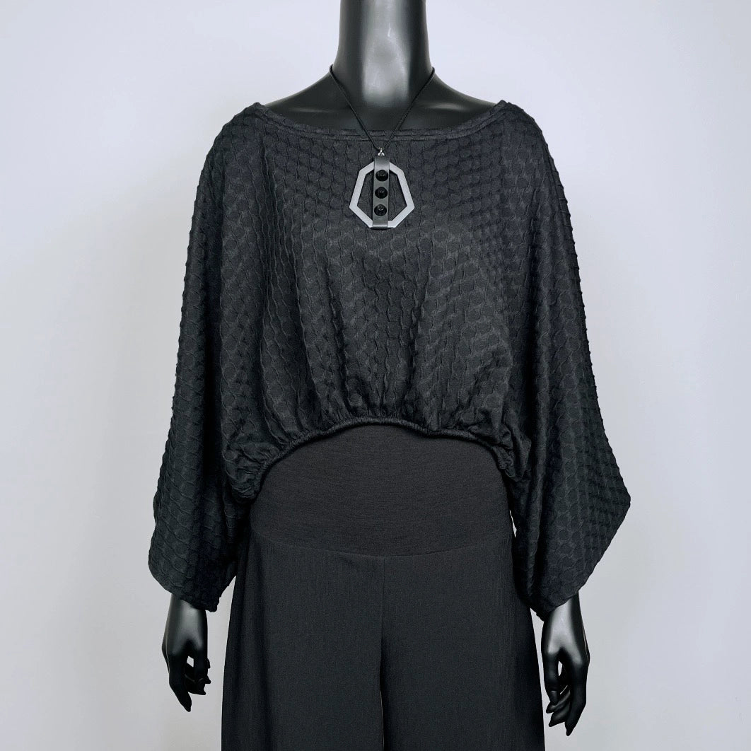 Black textured knit top with bat wing sleeves and gathered hemline black rubber necklace made in Melbourne 