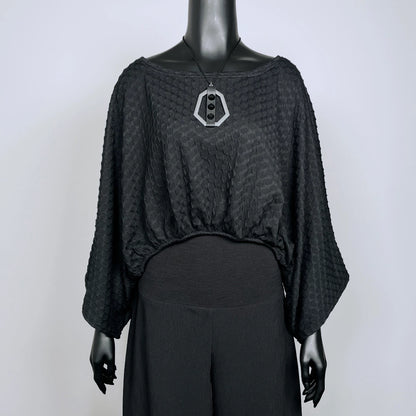 Black textured knit top with bat wing sleeves and gathered hemline black rubber necklace made in Melbourne 