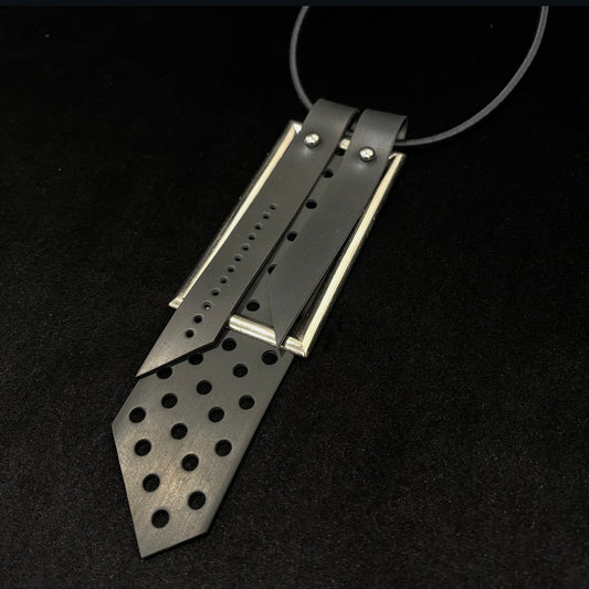 black rubber and Metallic pendant with perforated design on a black background