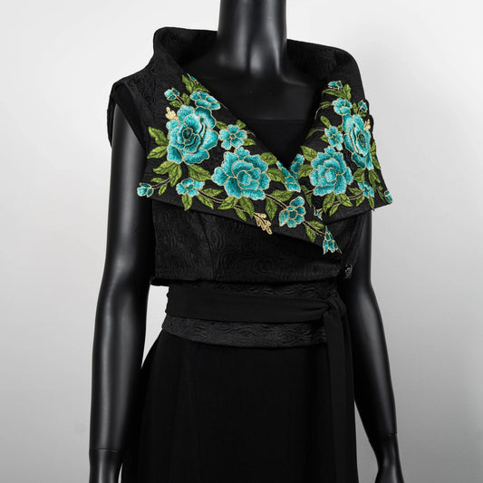Statement womans vest with high stand up collar and wide lapel with elaborate embroidered floral motifs in blue and green on black jacquard worn with black floral jacquard obi belt unique style evening wear event wear Melborune made Eloise the label