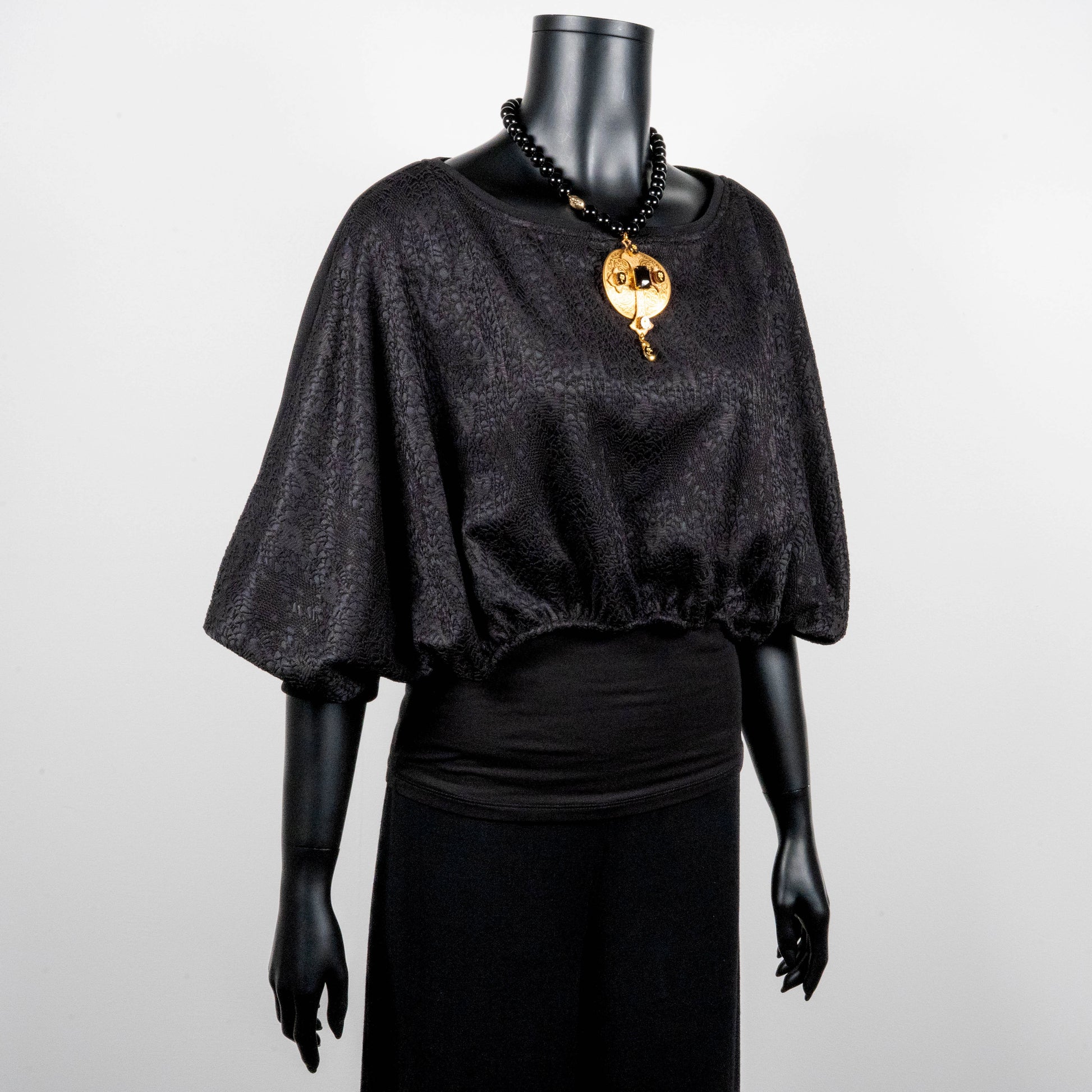 Black bonded lace jacquard top with batwing sleeves layering top gold cross necklace on black onyx beads made in Melbourne Eloise the label