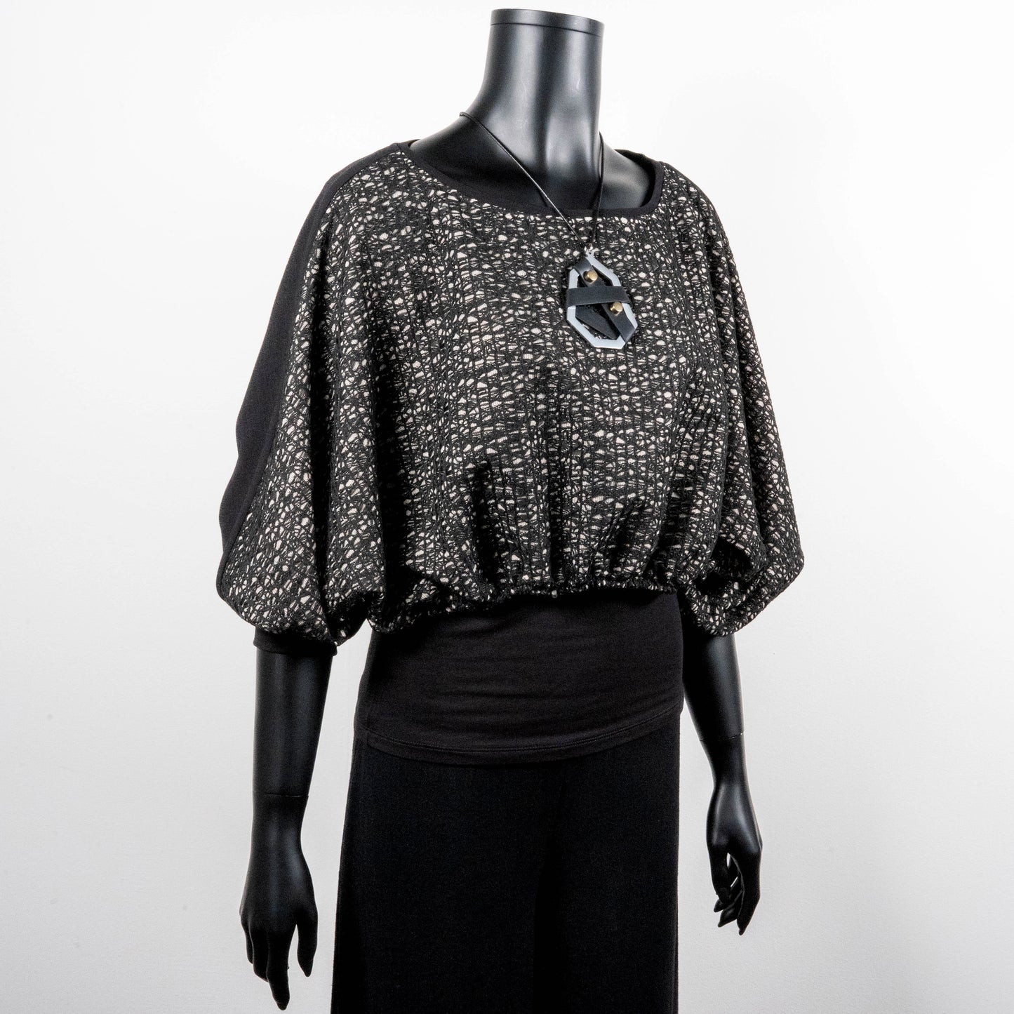 Black mesh jacquard top with bat wing sleeves and gathered hemline black rubber necklace made in Melbourne Eloise the label