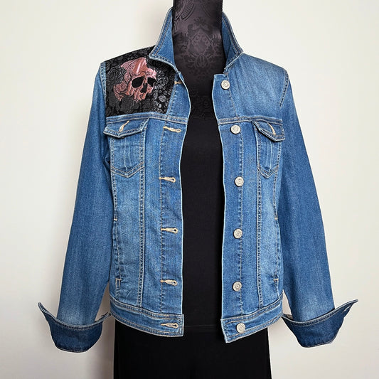 Upcycled blue denim jacket with skulls and roses in pink