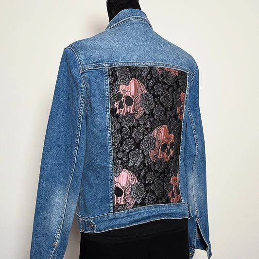 Upcycled blue denim jacket with skulls and roses in pink