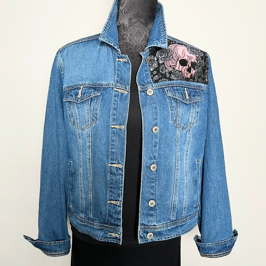 Upcycled blue denim jacket with skulls and roses in pink